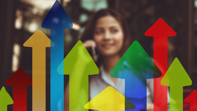 woman standing behind a row of colorful graphical arrows pointing up