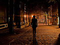 person walking alone down a dark street