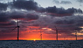 The sun rises behind an offshore wind farm. Image: Aaron via Flickr